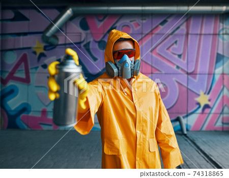 Graffiti artist pointing spray paint can to camera Graffiti artist pointing spray paint can to camera 74318865