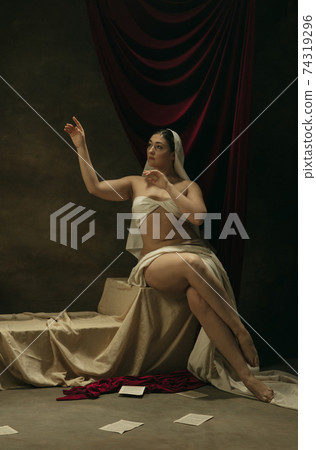 Modern remake of classical artwork - young medieval woman on dark background, comparison of eras concept 74319296