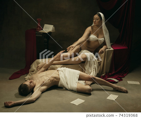 Modern remake of classical artwork - young medieval couple on dark background, comparison of eras concept Modern remake of classical artwork - young medieval couple on dark background, comparison of eras concept 74319368