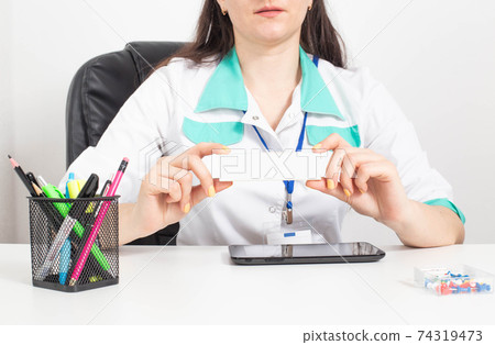 A female doctor holds in her hands a white pack of medicated ointment for the treatment of various diseases. Anti-inflammatory ointment, copy space A female doctor holds in her hands a white pack of medicated ointment for the treatment of various diseases. Anti-inflammatory ointment, copy space 74319473