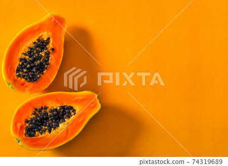 Papaya fruit orange color background Creative food sun shadow 74319689
