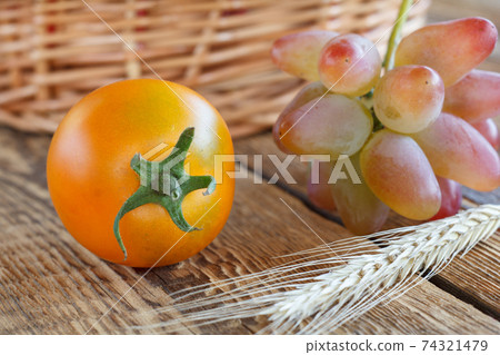 Tomato close-up over the wooden natural background Tomato close-up over the wooden natural background 74321479