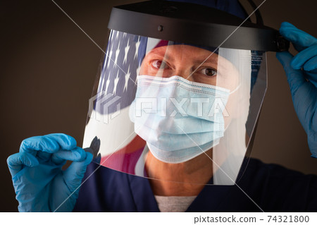 American Flag Reflecting on Female Medical Worker Wearing Protective Face Mask and Shield American Flag Reflecting on Female Medical Worker Wearing Protective Face Mask and Shield 74321800