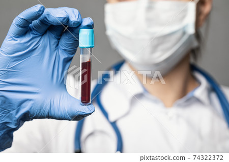 Doctor holding blood test tube Doctor holding blood test tube 74322372