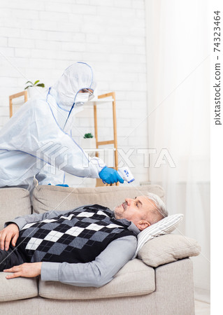 Old man sick infection, medical worker in hazmat suit examines patient and measures temperature with thermometer Old man sick infection, medical worker in hazmat suit examines patient and measures temperature with thermometer 74323464