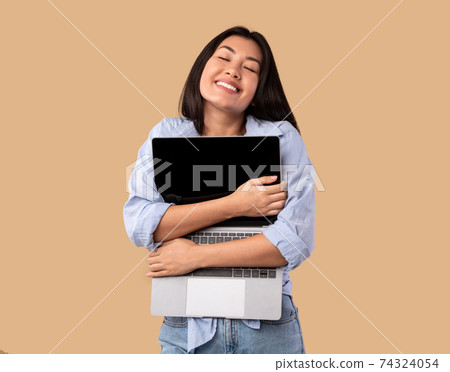 Technology Lover. Excited asian woman hugging personal computer Technology Lover. Excited asian woman hugging personal computer 74324054