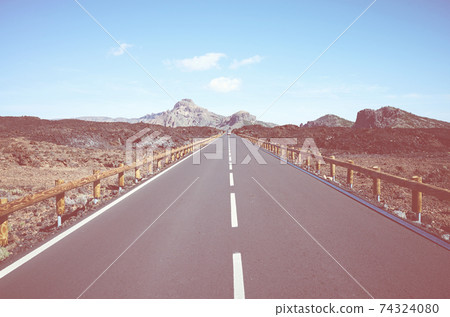 Retro toned picture of a road with volcanic scenery in Teide National Park, Tenerife, Spain. 74324080