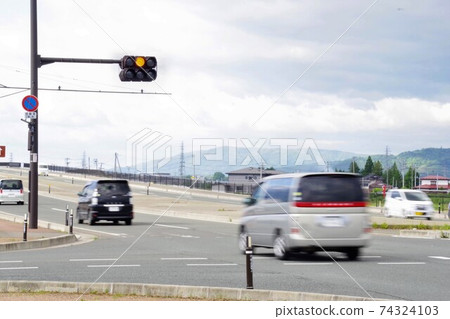 Cars entering the intersection at a yellow traffic light Cars entering the intersection at a yellow traffic light 74324103