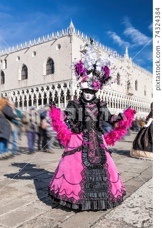 Colorful carnival masks at a traditional festival against Doge palace in Venice, Italy 74324384