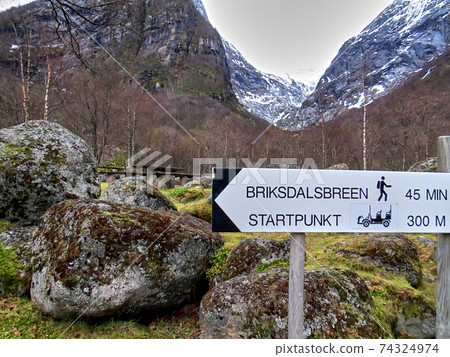 A sign showing the way to Briksdal glacier in Norway during winter 74324974