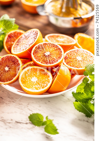 Blood sicilian oranges sliced on white plate with 74325569