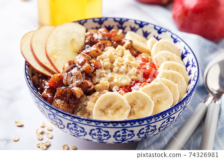 Homemade oatmeal for breakfast with apple, cinnamon and honey 74326981