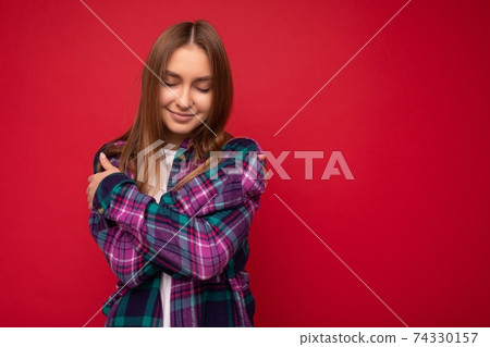 Photo of beautiful cute pretty young blonde woman wearing stylish purple shirt isolated over red 74330157
