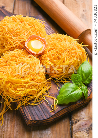 Tagliatelle pasta is thin. Traditional Italian named Angel Hair. Italian egg pasta, homemade and Tagliatelle pasta is thin. Traditional Italian named Angel Hair. Italian egg pasta, homemade and 74330823