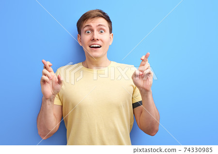good luck concept. cheerful guy holding fingers crossed 74330985