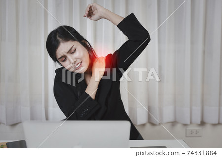 Young asian stressed businesswoman feeling pain or having problem with part of body arm shoulder or neck after working on computer for too long time. Office syndrome concept 74331884