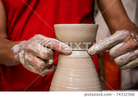 Man making ceramic articles on the pottery wheel in a traditional factory in the city of Raquira located in the department of Cundinamarca in Colombia Man making ceramic articles on the pottery wheel in a traditional factory in the city of Raquira located in the department of Cundinamarca in Colombia 74332566