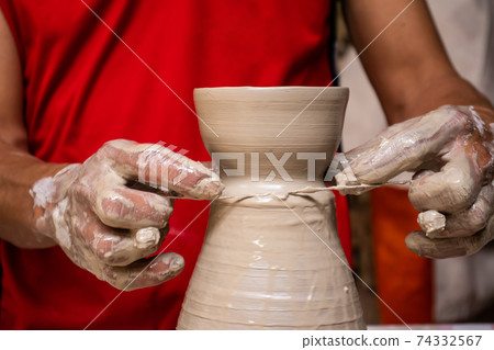 Man making ceramic articles on the pottery wheel in a traditional factory in the city of Raquira located in the department of Cundinamarca in Colombia Man making ceramic articles on the pottery wheel in a traditional factory in the city of Raquira located in the department of Cundinamarca in Colombia 74332567