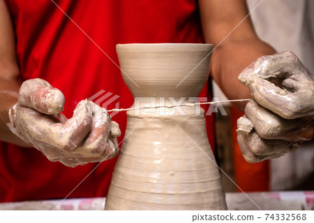 Man making ceramic articles on the pottery wheel in a traditional factory in the city of Raquira located in the department of Cundinamarca in Colombia Man making ceramic articles on the pottery wheel in a traditional factory in the city of Raquira located in the department of Cundinamarca in Colombia 74332568