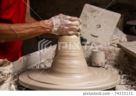 Man making ceramic articles on the pottery wheel in a traditional factory in the city of Raquira located in the department of Cundinamarca in Colombia Man making ceramic articles on the pottery wheel in a traditional factory in the city of Raquira located in the department of Cundinamarca in Colombia 74333131