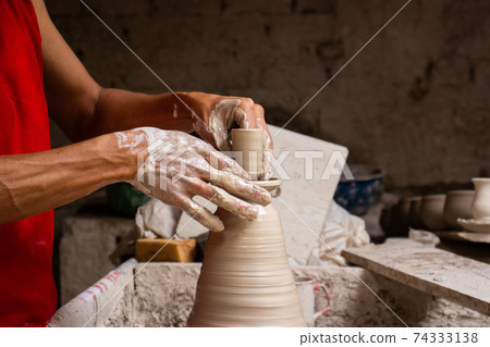 Man making ceramic articles on the pottery wheel in a traditional factory in the city of Raquira located in the department of Cundinamarca in Colombia Man making ceramic articles on the pottery wheel in a traditional factory in the city of Raquira located in the department of Cundinamarca in Colombia 74333138