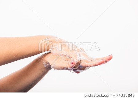 Woman washing hands by soap for cleanliness 74333848