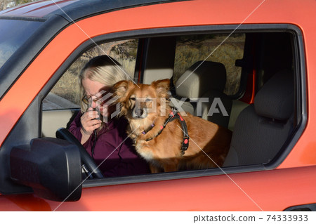 Woman ham amateur radio operator making a voice SSB contact from car with her dog sitting beside her Woman ham amateur radio operator making a voice SSB contact from car with her dog sitting beside her 74333933