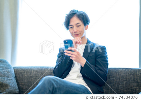 Man looking at a smartphone 74334076