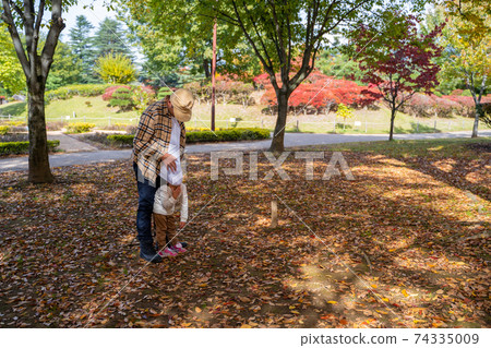 Father and child playing in the autumn park Father and child playing in the autumn park 74335009