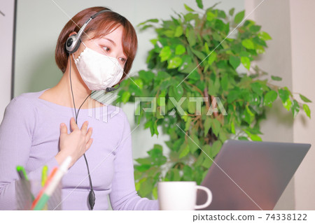 一名婦女在網上會議上戴著面具和談論她的想法 一名婦女在網上會議上戴著面具和談論她的想法 74338122