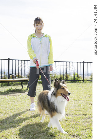 年輕女子在公園裡walking狗 74341394