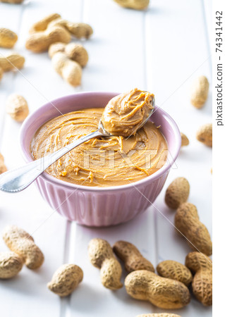 Peanut butter in bowl and peanuts Peanut butter in bowl and peanuts 74341442