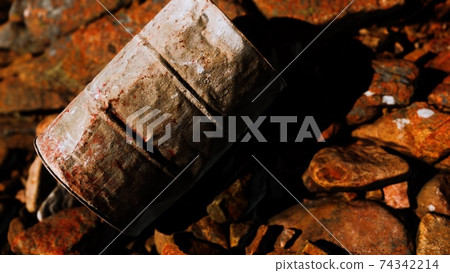 rusty destroyed metal barrel on beach rocks rusty destroyed metal barrel on beach rocks 74342214