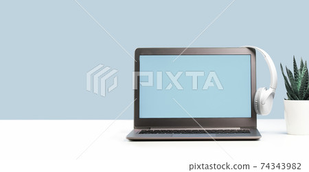 Laptop with wireless headphones on white desk Laptop with wireless headphones on white desk 74343982
