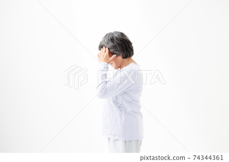 Senior woman worried about holding her head Senior woman worried about holding her head 74344361