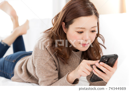 A woman operating a smartphone A woman operating a smartphone 74344989