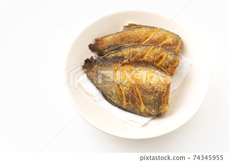 Deep-fried fishes or Snakeskin gourami fish in the round disk on white background with clipping path. The fish is called Pla Salid or Slid in Thailand language. Deep-fried fishes or Snakeskin gourami fish in the round disk on white background with clipping path. The fish is called Pla Salid or Slid in Thailand language. 74345955