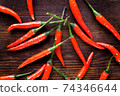 Group of chilli peppers on wood background 74346644