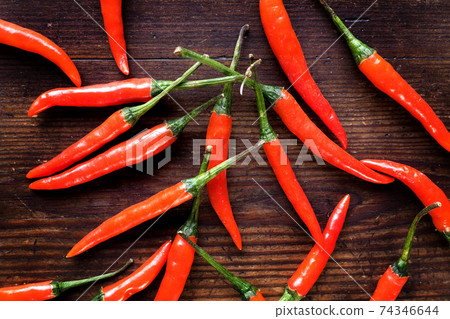 Group of chilli peppers on wood background Group of chilli peppers on wood background 74346644
