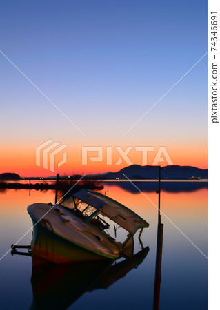[滋賀]被遺棄的船和夕陽下照亮的賽諾科湖的倒影 74346691