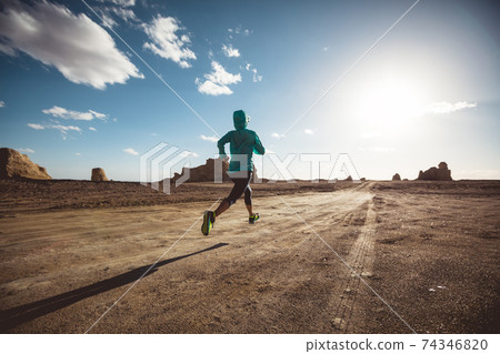 Fitness woman trail runner cross country running on sand desert Fitness woman trail runner cross country running on sand desert 74346820