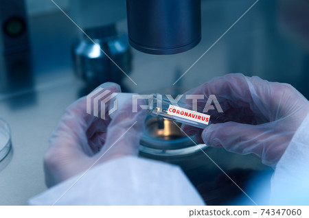 Closeup of microbiologist's hand opening test tube with coronavirus vaccine Closeup of microbiologist's hand opening test tube with coronavirus vaccine 74347060
