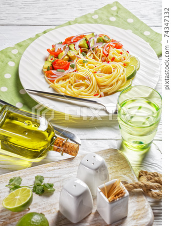 pasta with avocado, tomatoes and lime, top view pasta with avocado, tomatoes and lime, top view 74347132