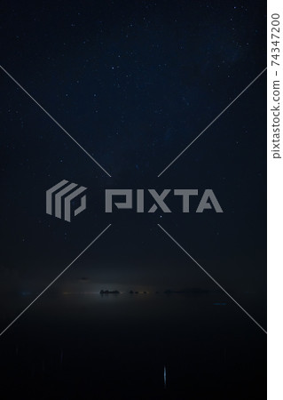 Vertical image of Stardust in the night with noise and grain on the sky with soft light of city in bottom Vertical image of Stardust in the night with noise and grain on the sky with soft light of city in bottom 74347200