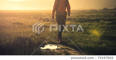 Woman backpacker hiking in high altitude nature Woman backpacker hiking in high altitude nature 74347608