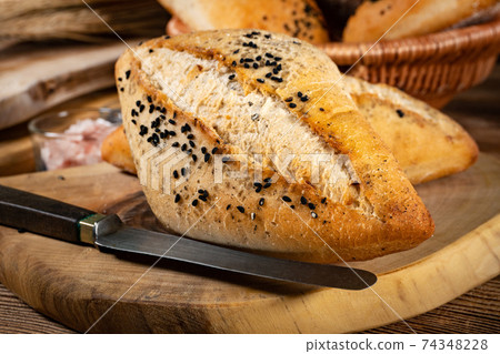 Fresh bread rolls on a rustic wooden table. 74348228