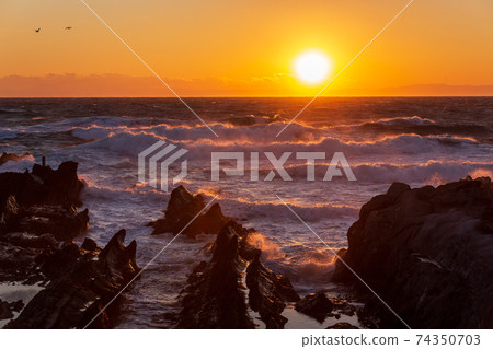 The setting sun that dyes the roughest sea in spring from the Arasaki coast 74350703