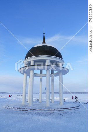 City rotunda on shore of frozen snowy lake in winter on a sunny frosty day 74351589