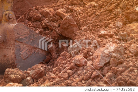 Backhoe working by digging soil at construction site. Bucket teeth of backhoe digging soil. Crawler excavator digging on soil. Excavating machine. Earth moving machine. Excavation vehicle. Backhoe working by digging soil at construction site. Bucket teeth of backhoe digging soil. Crawler excavator digging on soil. Excavating machine. Earth moving machine. Excavation vehicle. 74352598