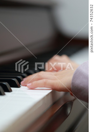 5-year-old girl playing an upright piano 74352632